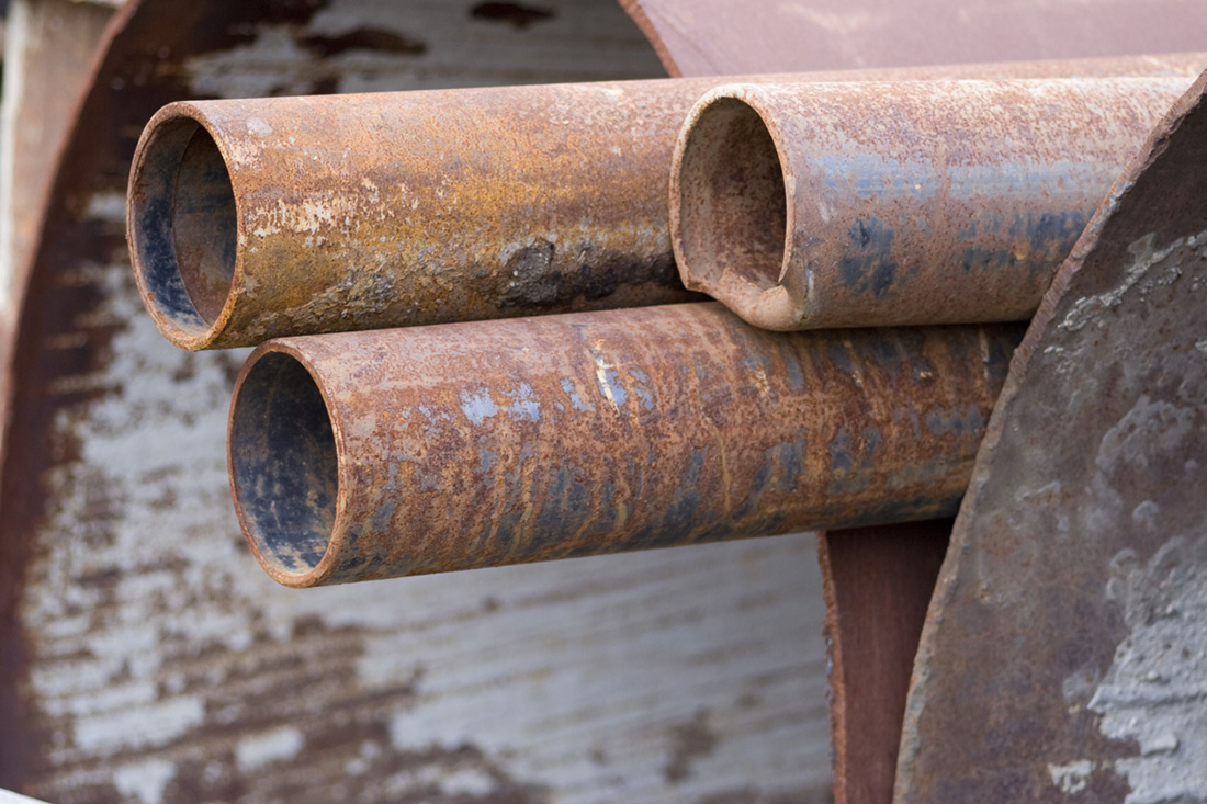 Three smaller pipes are centered against two very large pipes.